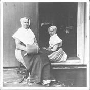 SA1424 - Two Shaker women sitting in a doorway. Image used for an article on Shaker furniture. Illustration for Junior Bazaar, Winterthur Shaker Photograph and Post Card Collection 1851 to 1921c